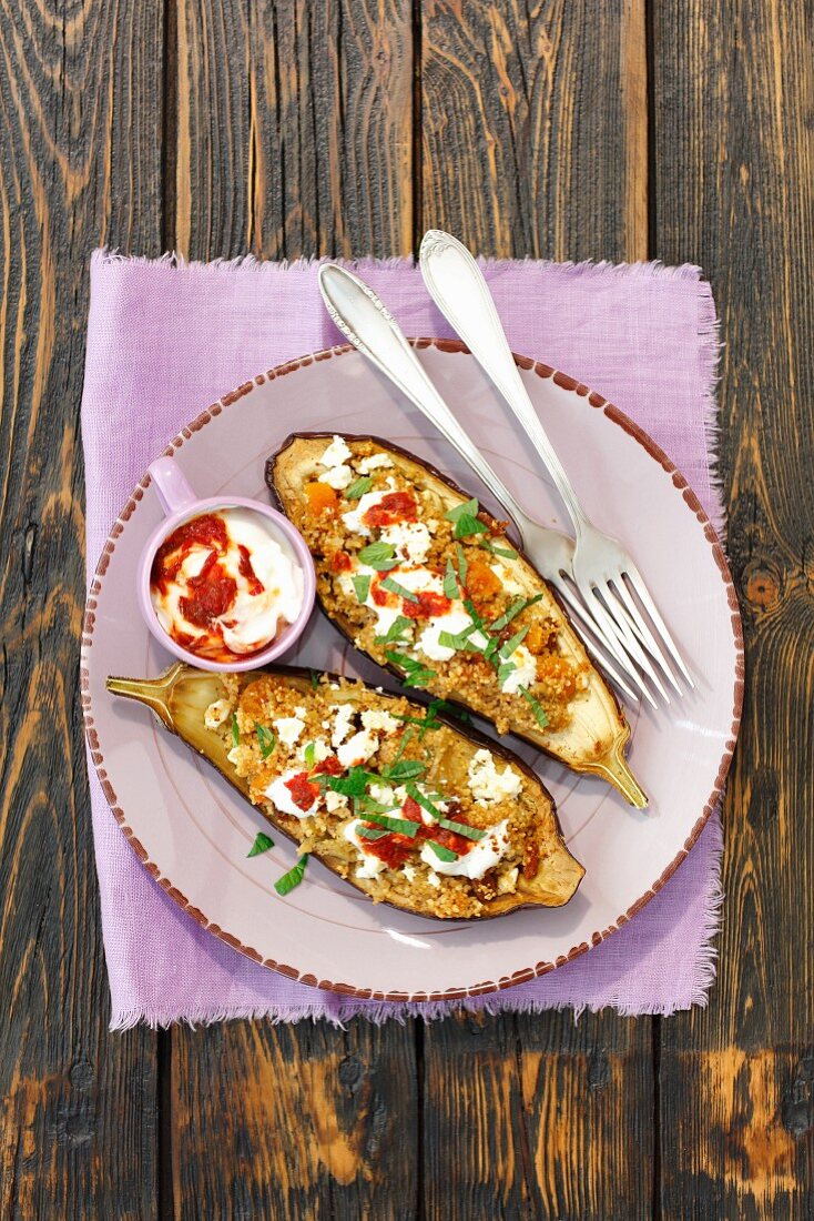 Stuffed aubergines with couscous and feta on a plate (top view)