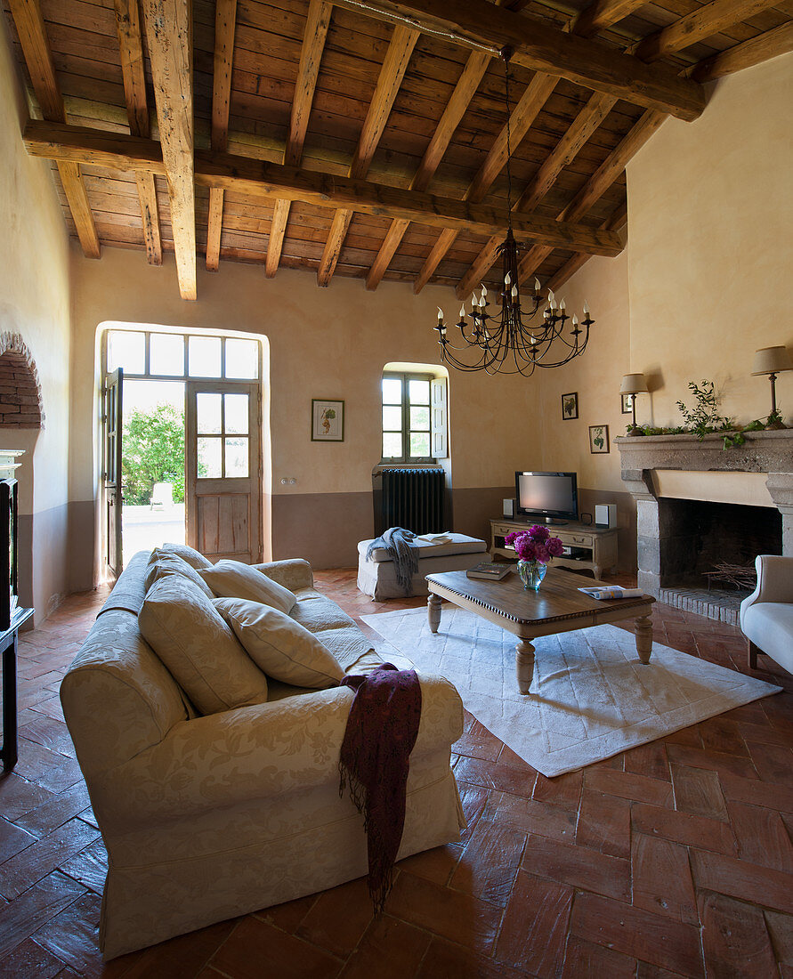 Exposed roof structure in Mediterranean living room with door leading into garden