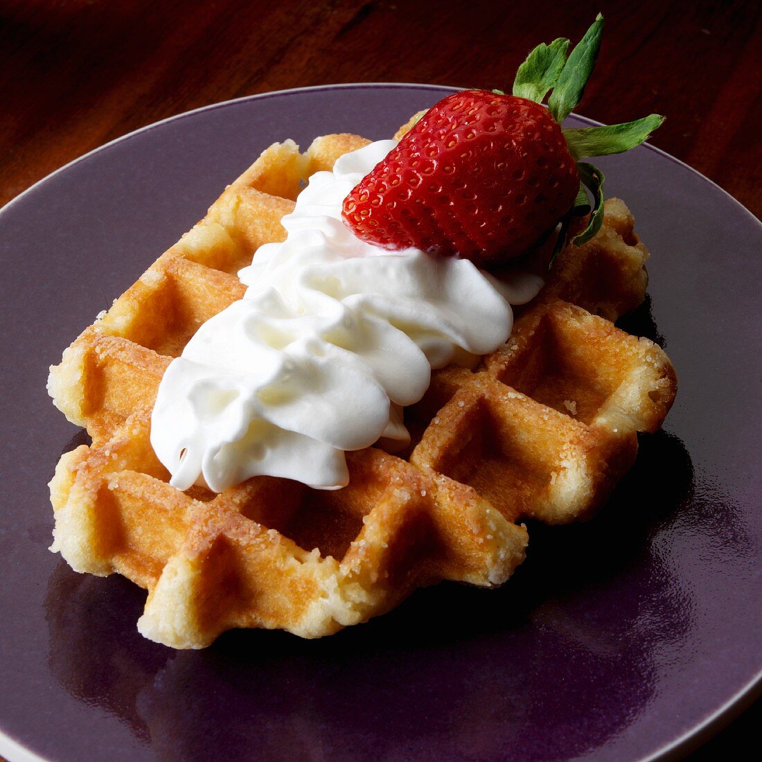 Belgian waffle with whipped cream and one strawberry