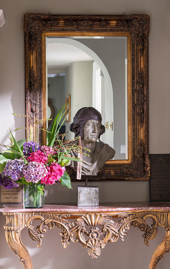 Bust and vase of flowers on carved, antique console table