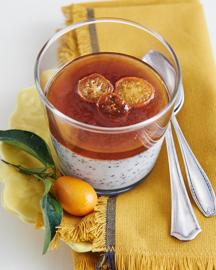 Panna cotta in a glass with poppyseeds, orange jelly and candied kumquats