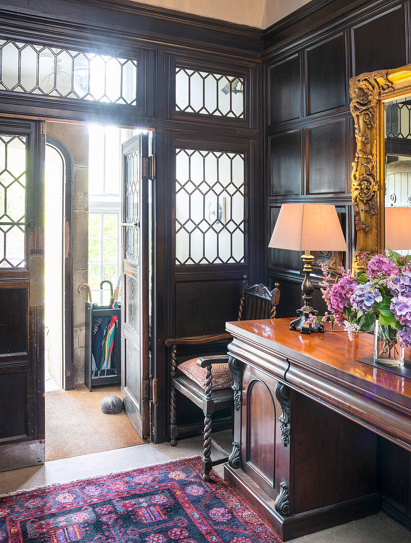 Antique console table in foyer with leaded glass windows