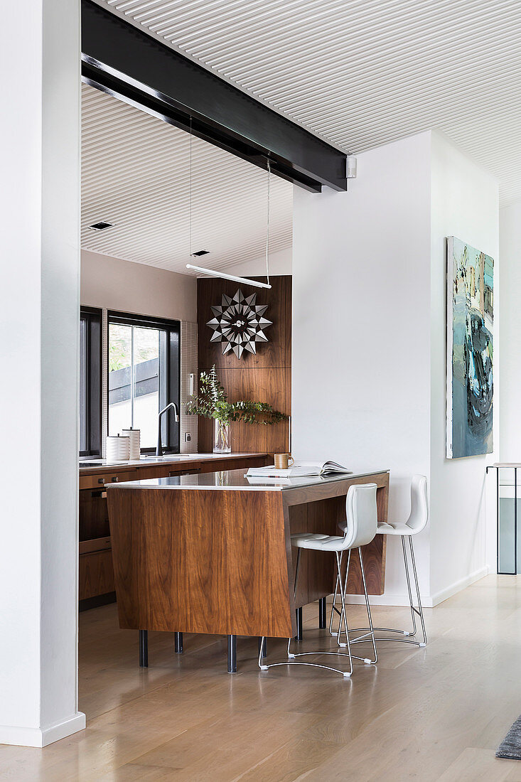 Elegante Kücheninsel mit Barhockern zwischen Küche und Wohnzimmer