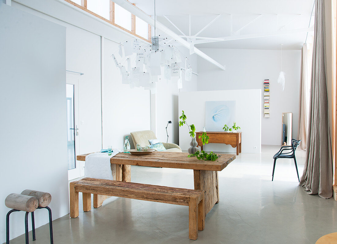 Modern dining room with concrete floor and wooden furniture in loft apartment