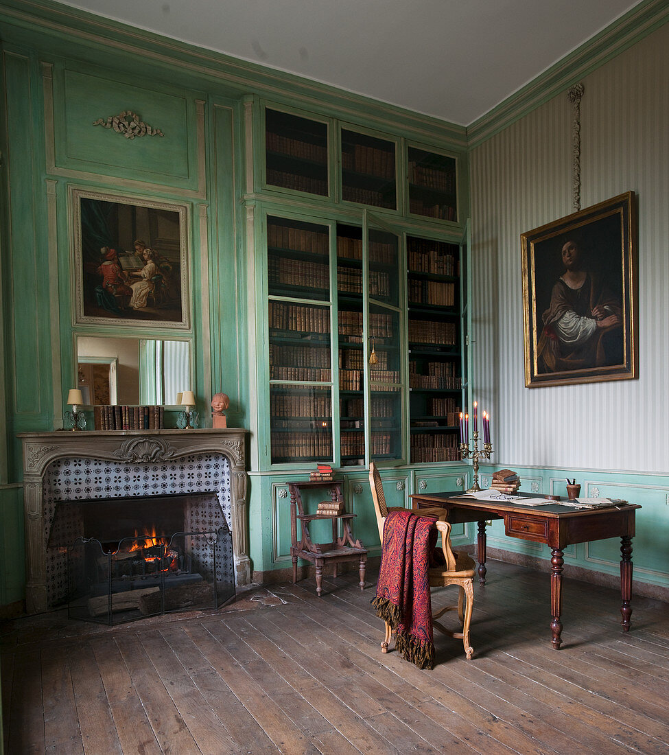 Historische Bibliothek grüner Wandvertäfelung und offenem Kamin