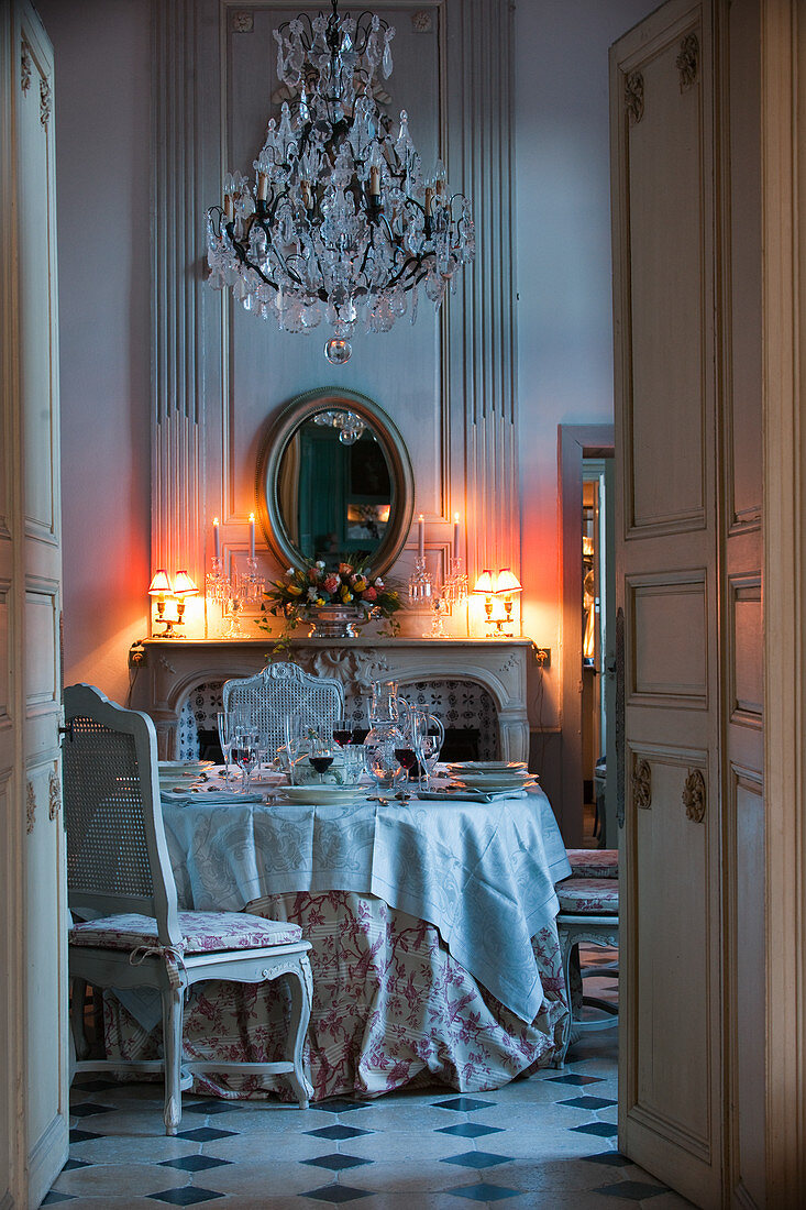 View through open double doors to set table in candlelit room