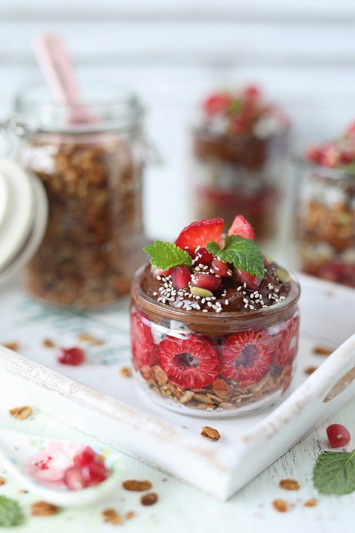Cereal with chocolate and avocado mousse and raspberries in glass jars