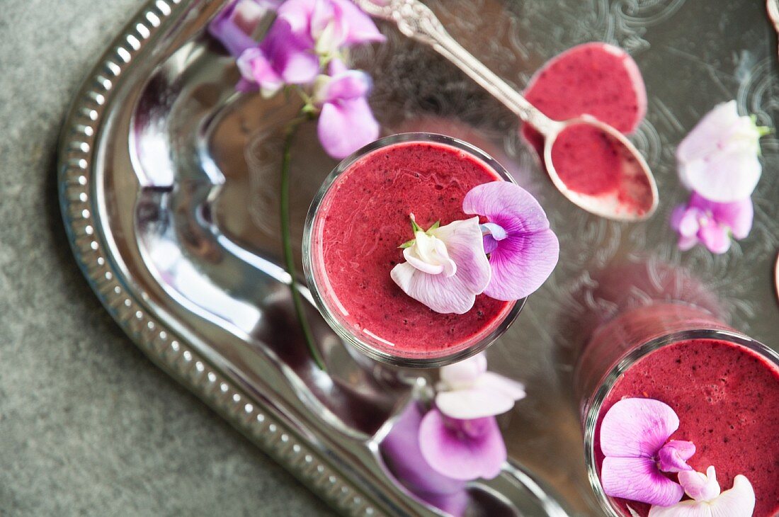 Vegan raspberry smoothie with almond milk on a silver tray (seen from above)
