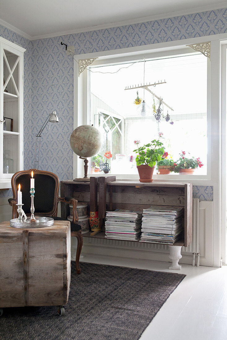 Magazines in sideboard made from wooden box on urns in living room