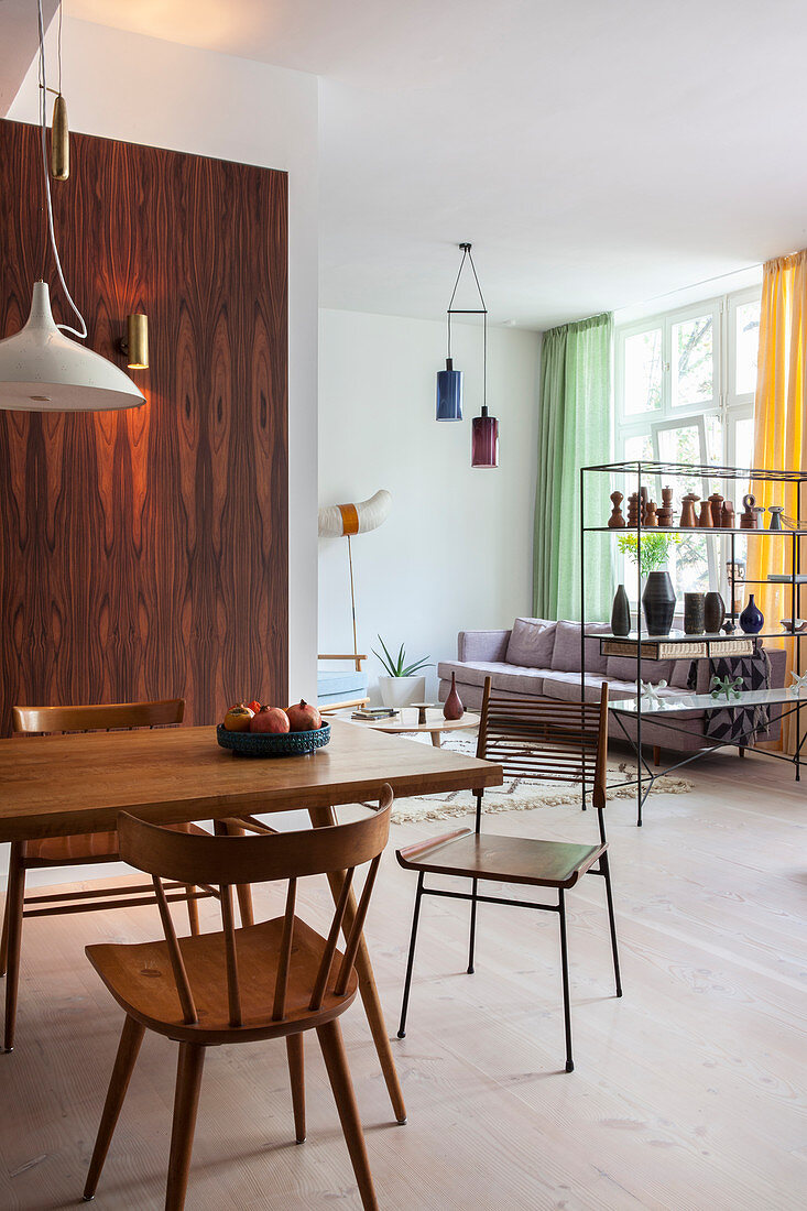 View past wooden furniture in dining area and wooden wall into living room