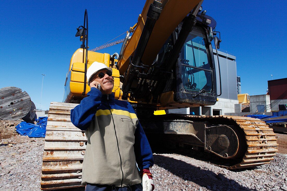 Surveyor on construction site with bulldozer