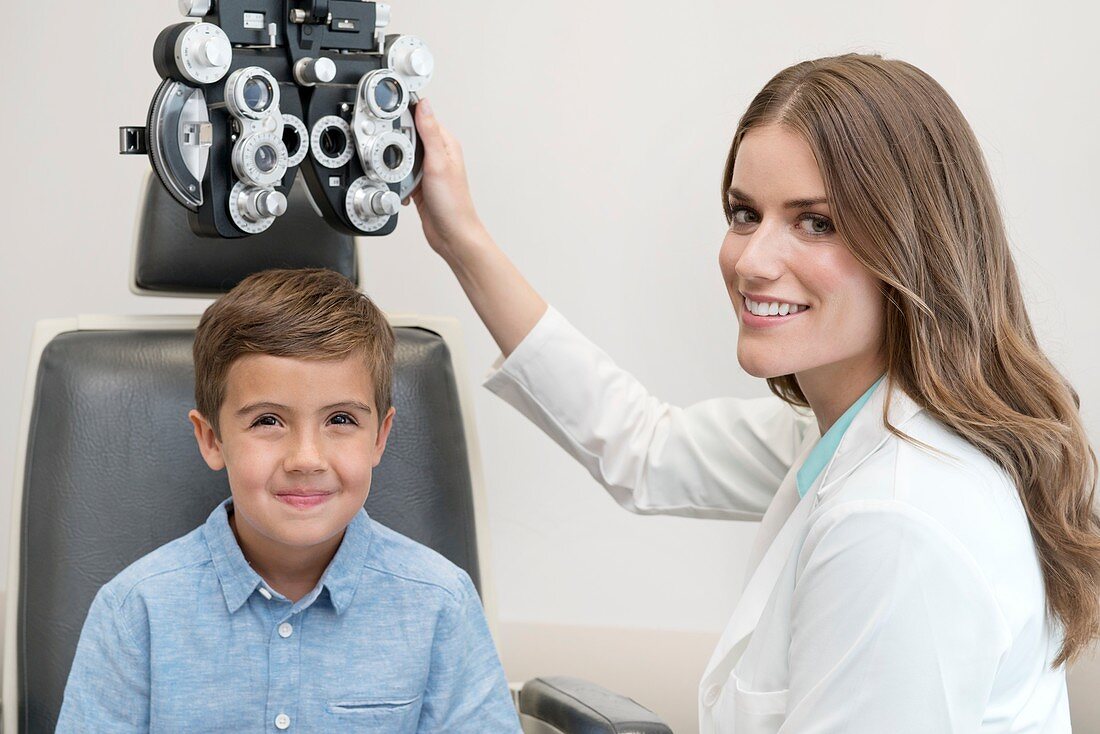 Female optician and boy