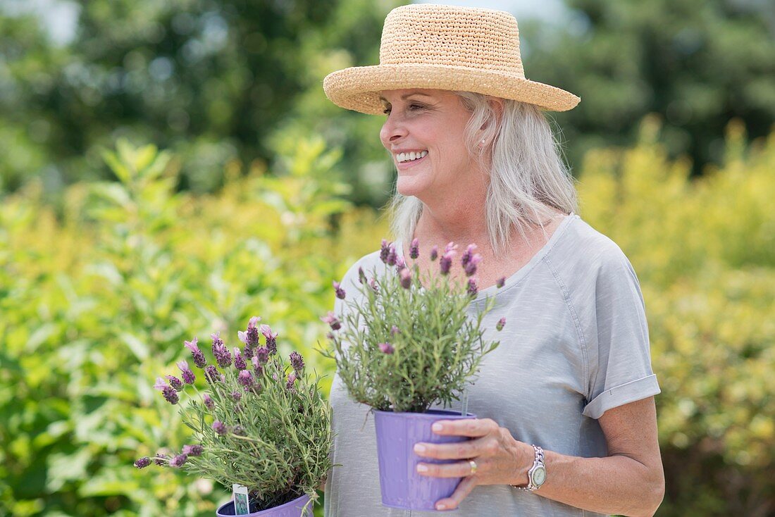 Senior woman holding pot plants