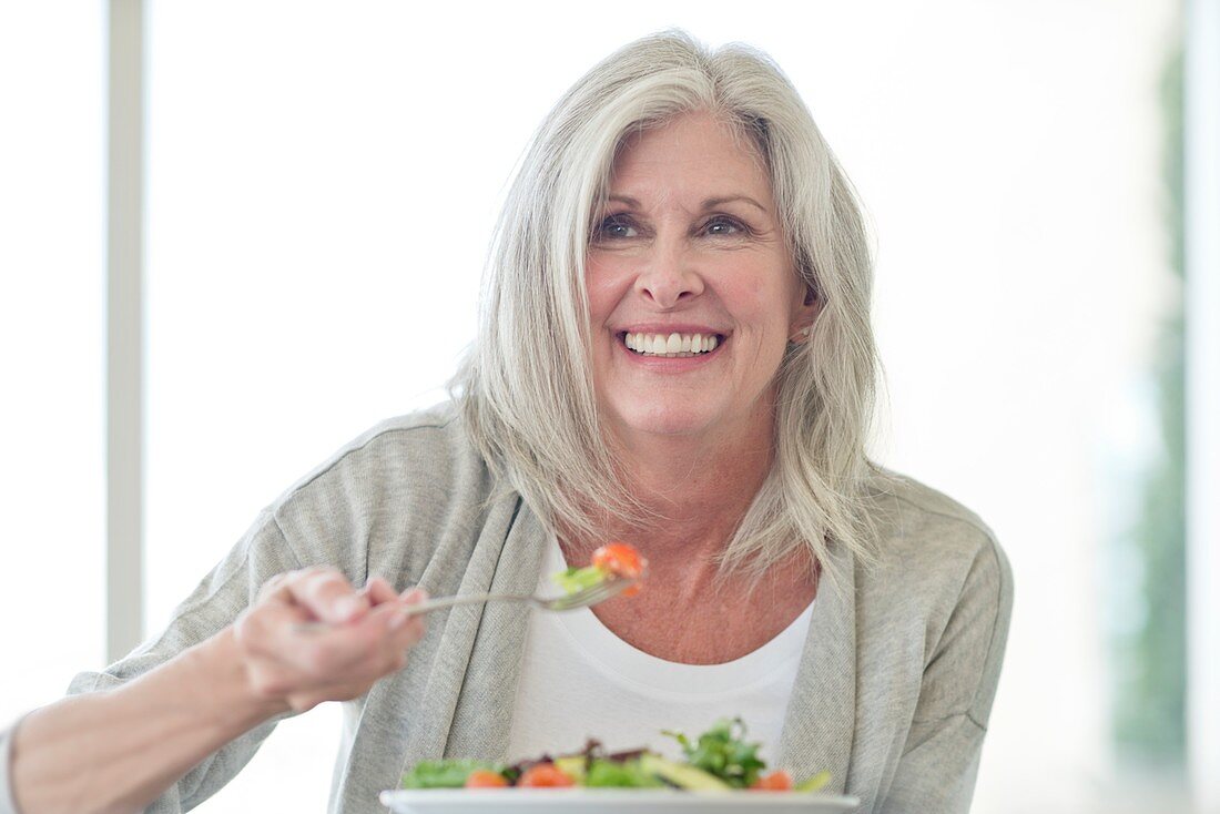 Senior woman eating salad