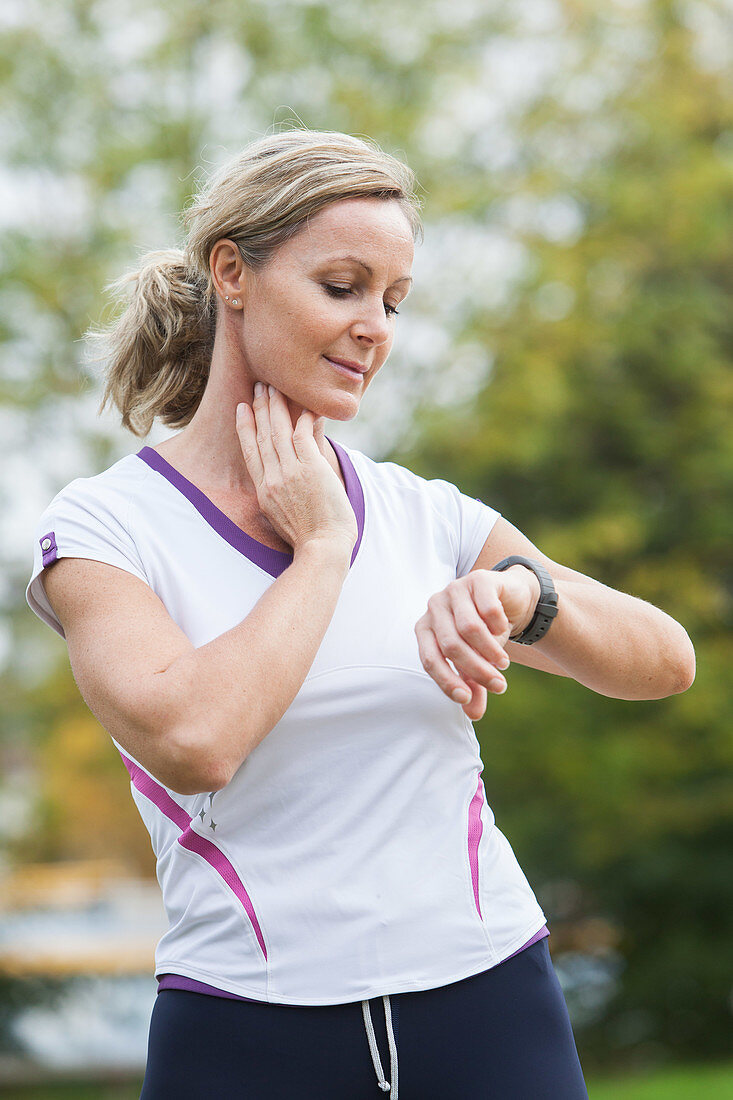 Woman checking her pulse after exercising