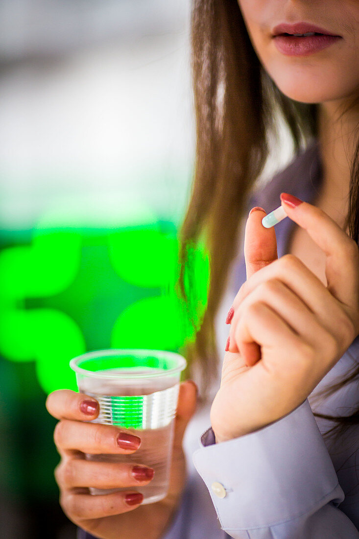 Woman taking gelatine capsule medication