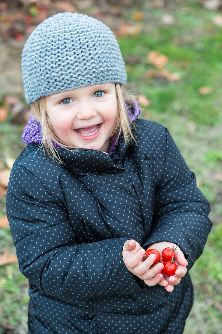 Girl holding tomatoes from garden