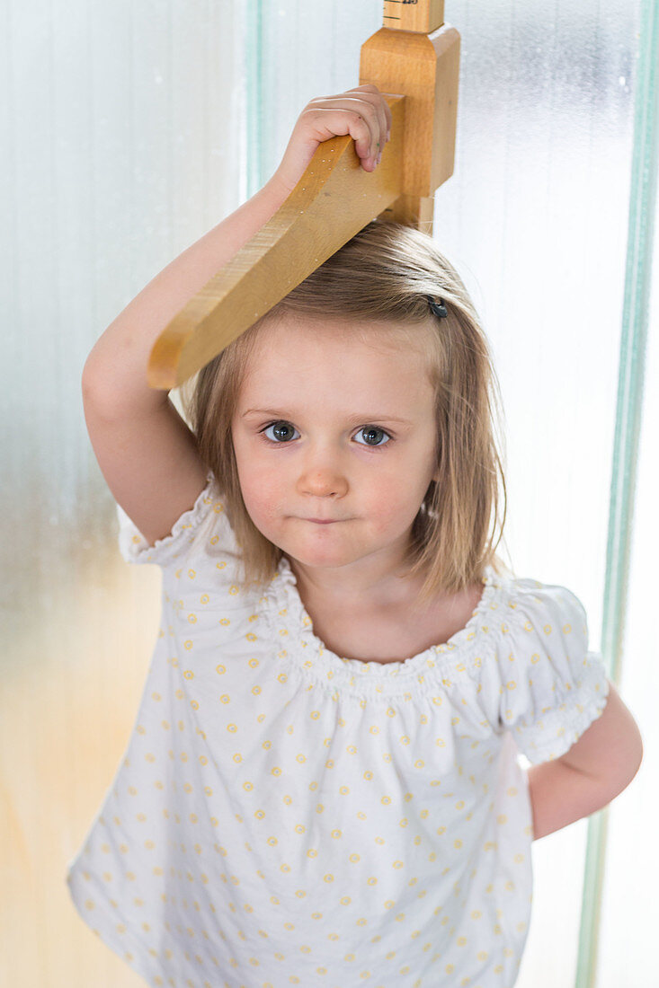 3-year-old girl measuring herself