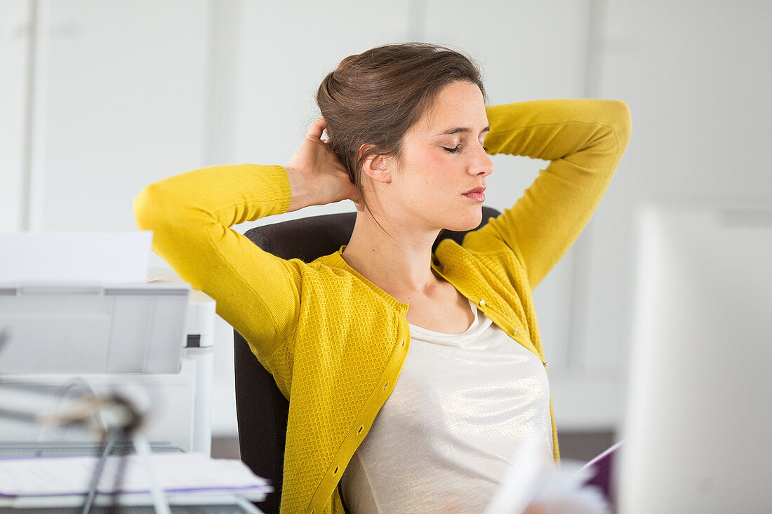 Woman relaxing and stretching arms at work