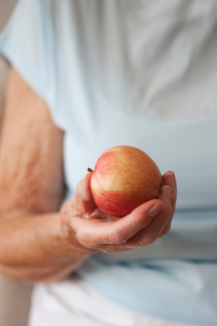 Elderly woman holding an apple