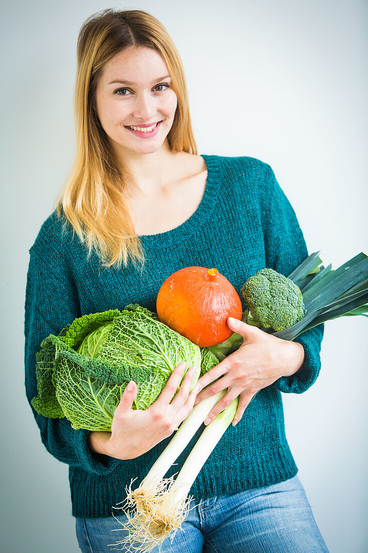 Woman holding vegetables in her arms