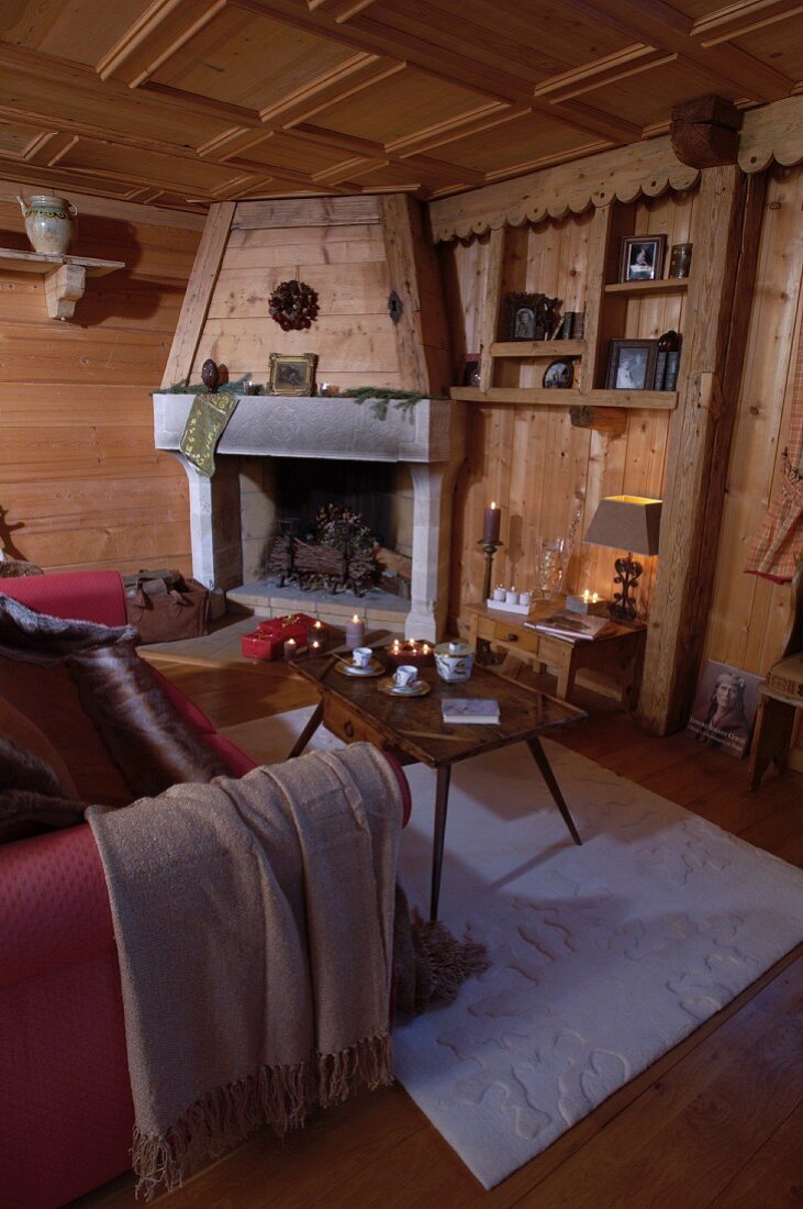 Uriges Wohnzimmer im Landhausstil mit offenem Kamin und Kassettendecke