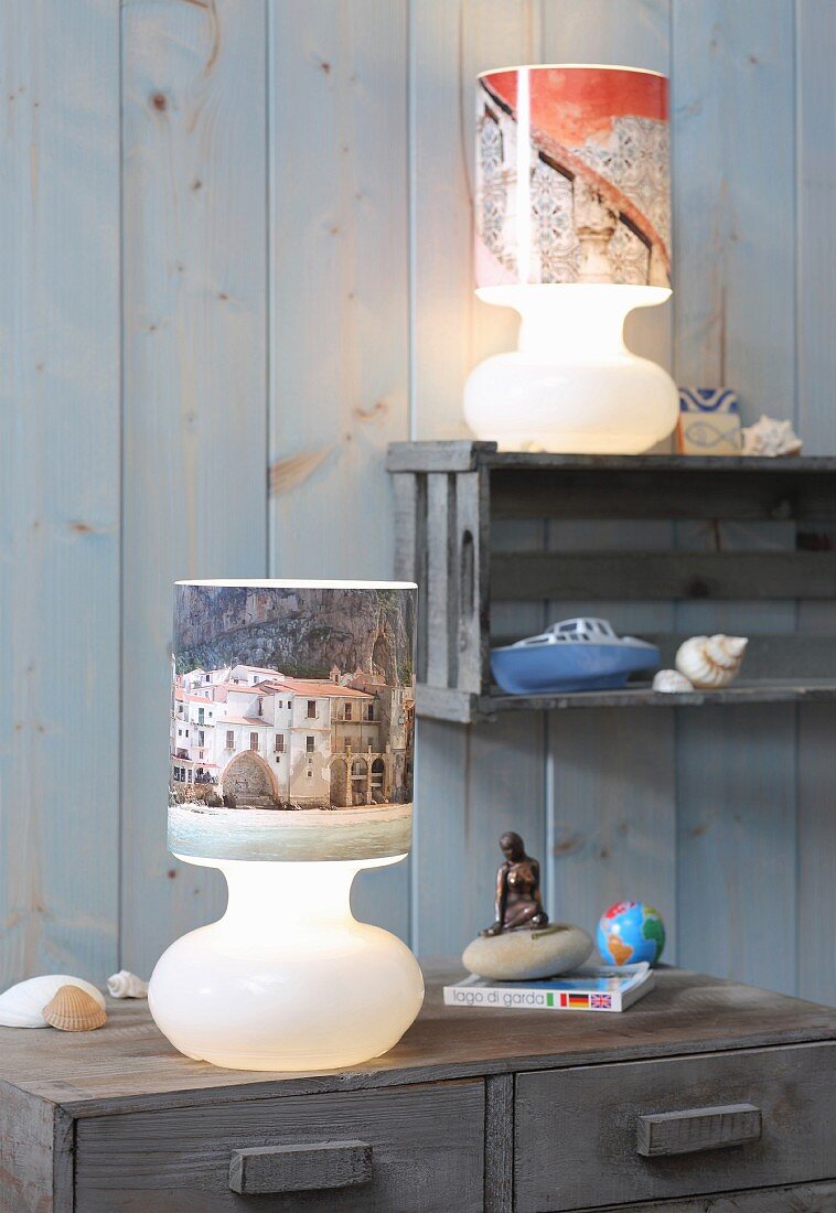 Table lamps with lampshades covered in holiday photos against board wall