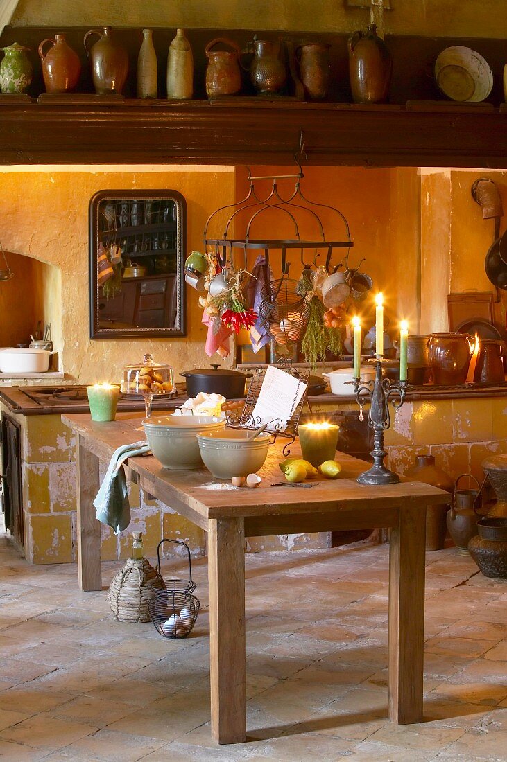 Küchentisch mit Backutensilien und Kerzenschein in rustikaler Küche