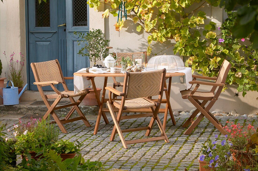 Sunny seating area on terrace outside traditional country house