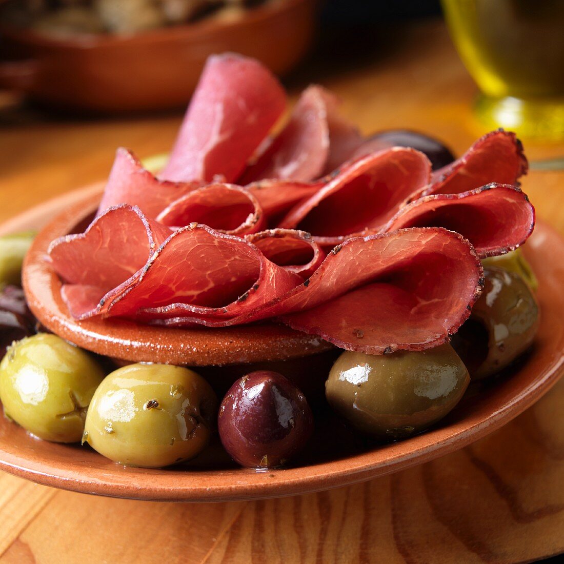 Bresaola (luftgetrocknetes Rindfleisch, Italien) und Oliven