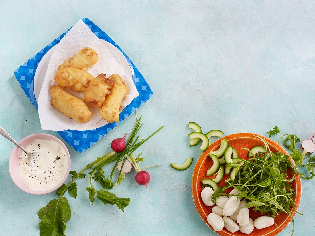 Fried fish with ingredients for gnocchi and radish salad with cucumber