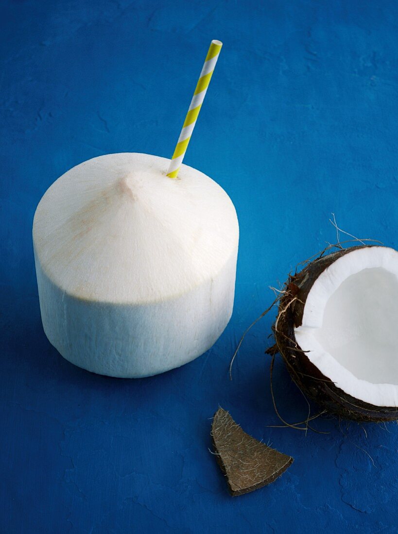 Geschälte Kokosnuss mit Strohhalm