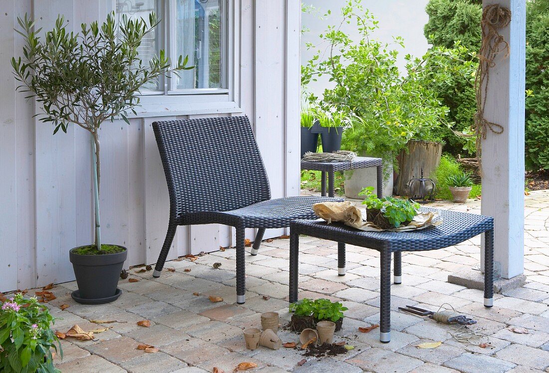 Moderner Polyrattansessel und Fußhocker auf der Terrasse