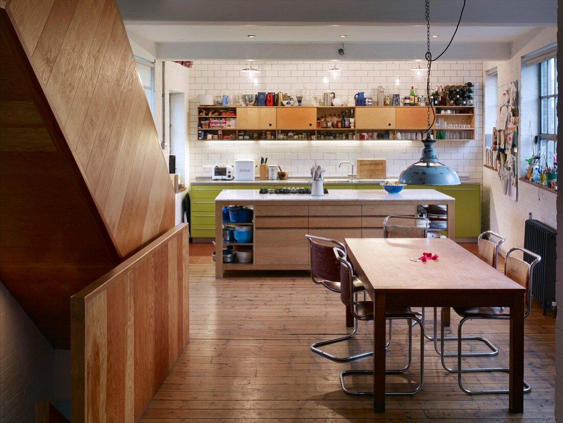 Island counter and dining area with cantilever chairs in open-plan kitchen