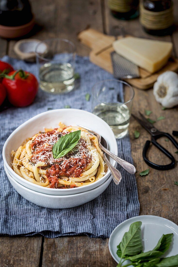 Makkaroni mit Tomatensauce und Basilikum auf rustikalem Holztisch