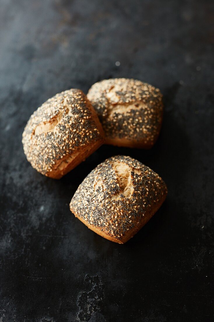 Three multigrain bread rolls with poppy seeds