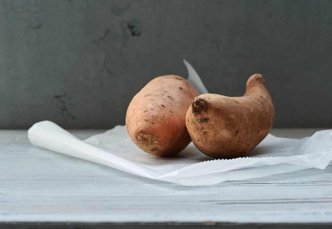 Several sweet potatoes on a piece of paper