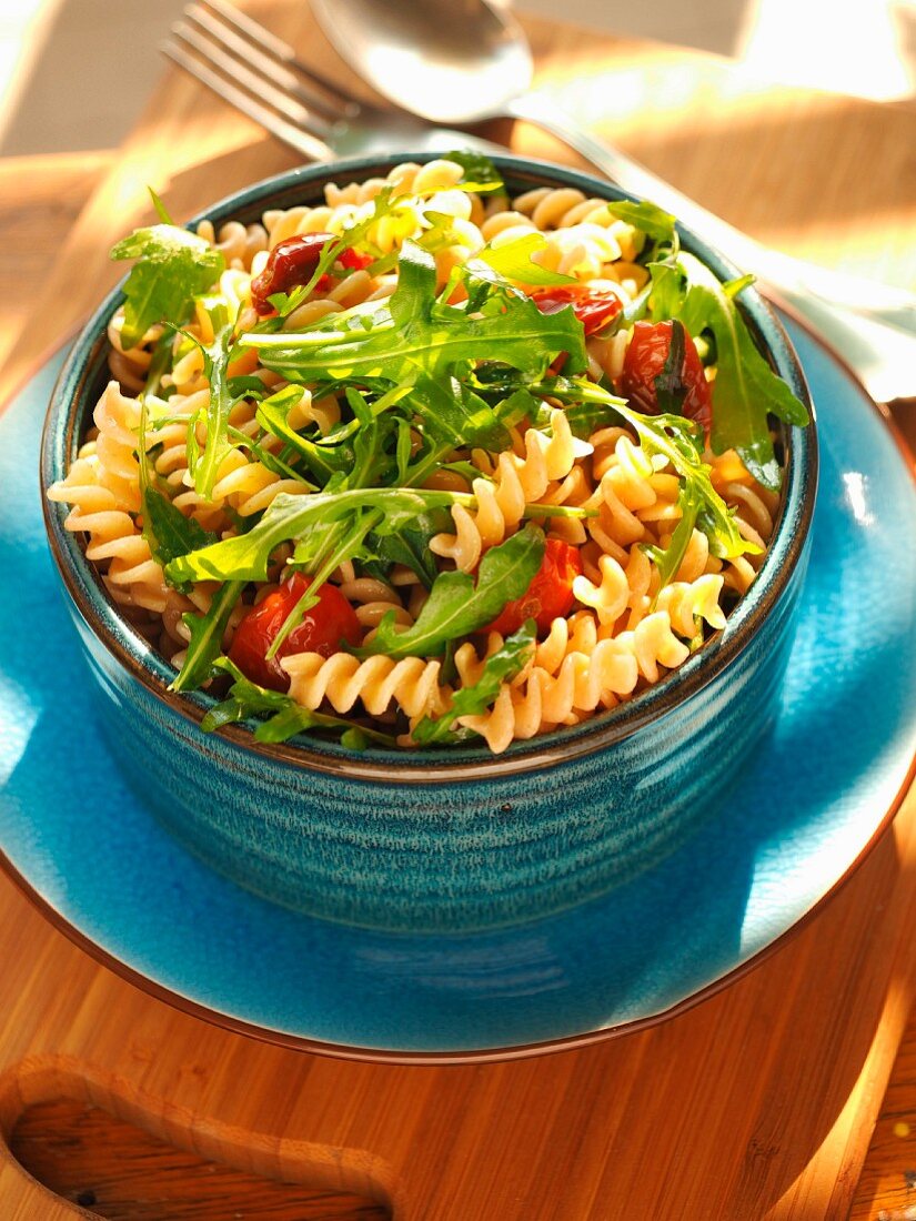 Whole wheat tortiglioni pasta cold with rocket salad, dried Pachino tomatoes and italian extra virgin olive oil, Italy