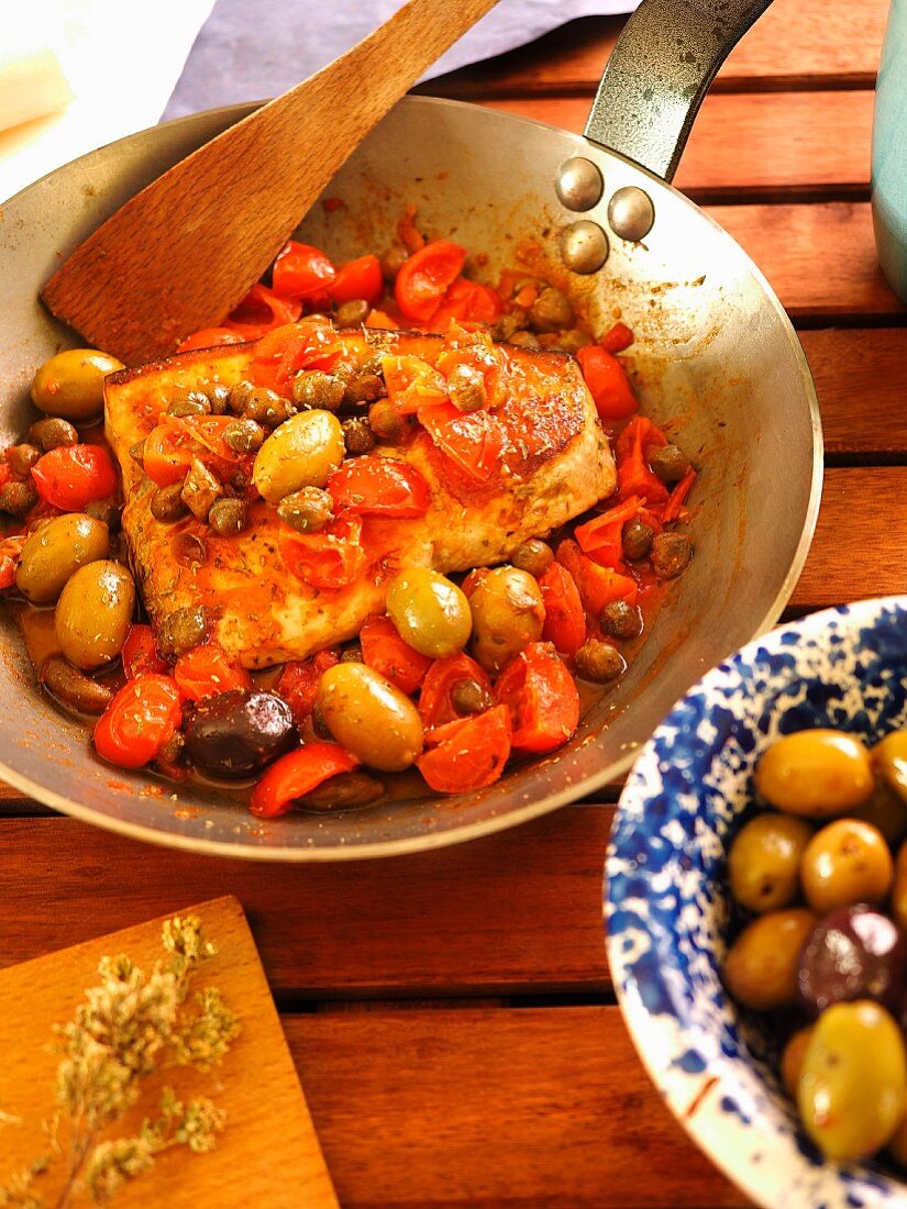 Pesce Spada alla Ghiotta (Traditionelles Schwertfischgericht mit Kapern, Oliven und Tomaten, Kalabrien, Italien)