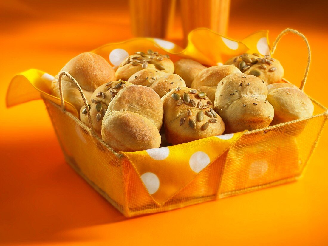 Bread rolls with caraway seeds and sunflower seeds in a bread basket