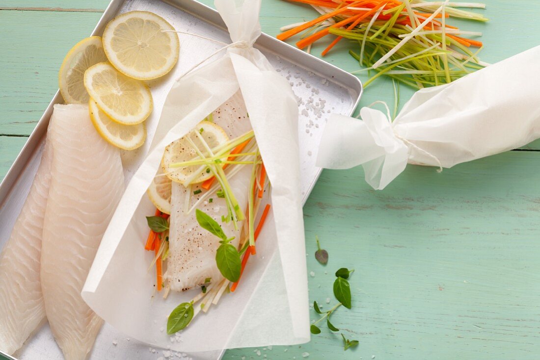 Ingredients for making fish fillets with vegetables wrapped in parchment paper