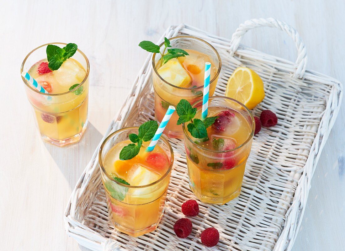 Fruity iced tea with mint on a white basket tray