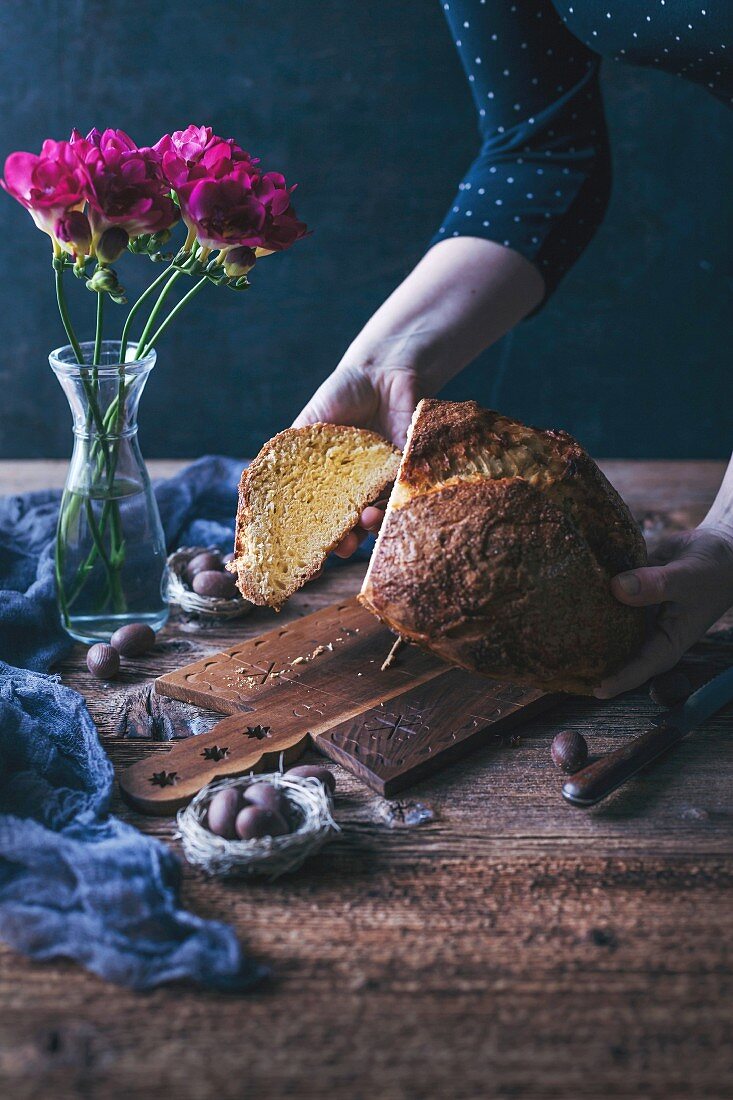 Frau hält frisch gebackenes Osterbrot in den Händen