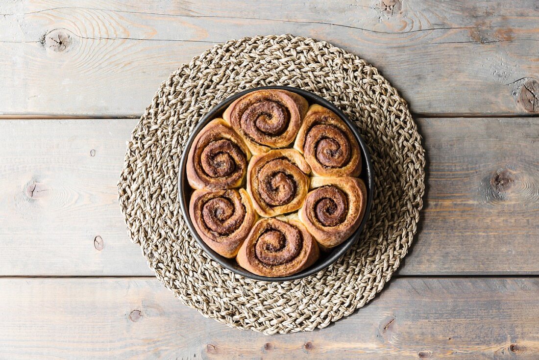 Cinnamon and cardomom buns in a pan on a kitchen table