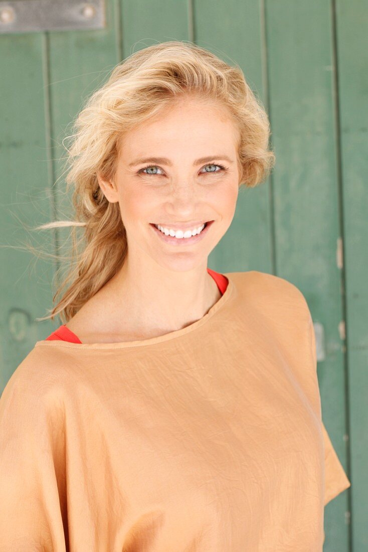 A blonde woman wearing a bronze blouse