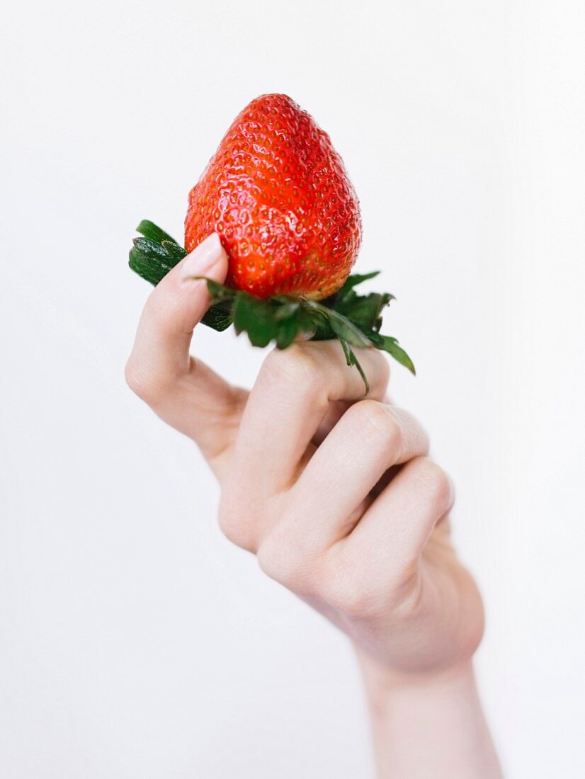 Frau hält frische Erdbeere