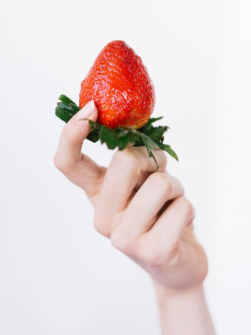 Woman holding fresh strawberry