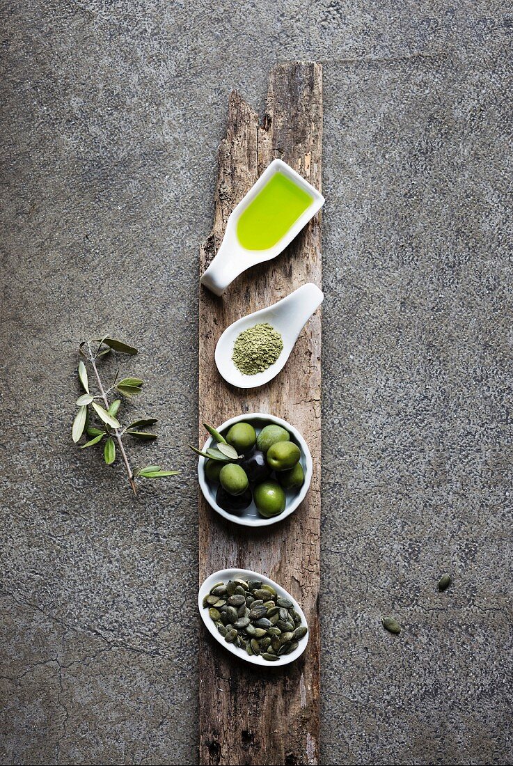 Grüne Lebensmittel: Olivenöl, Machatee, Oliven und Kürbiskerne