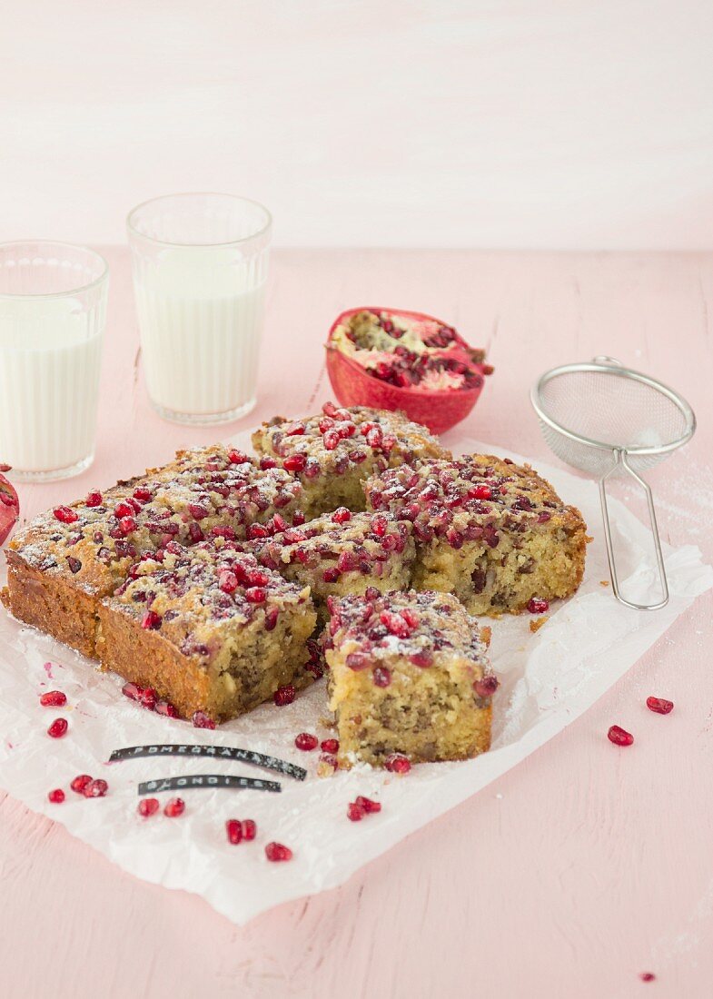 Sliced blondies with pomegranate seeds on a piece of parchment paper
