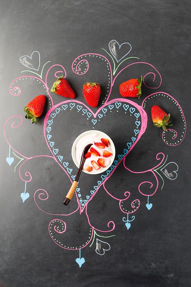 A strawberry dessert on a decorated blackboard